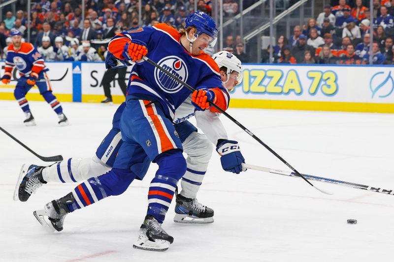 Jan 16, 2024; Edmonton, Alberta, CAN; Edmonton Oilers forward Warren Foegele (37) tries to move the puck around Toronto Maple Leafs defensemen Morgan Rielly (44) during the first period at Rogers Place. Mandatory Credit: Perry Nelson-USA TODAY Sports