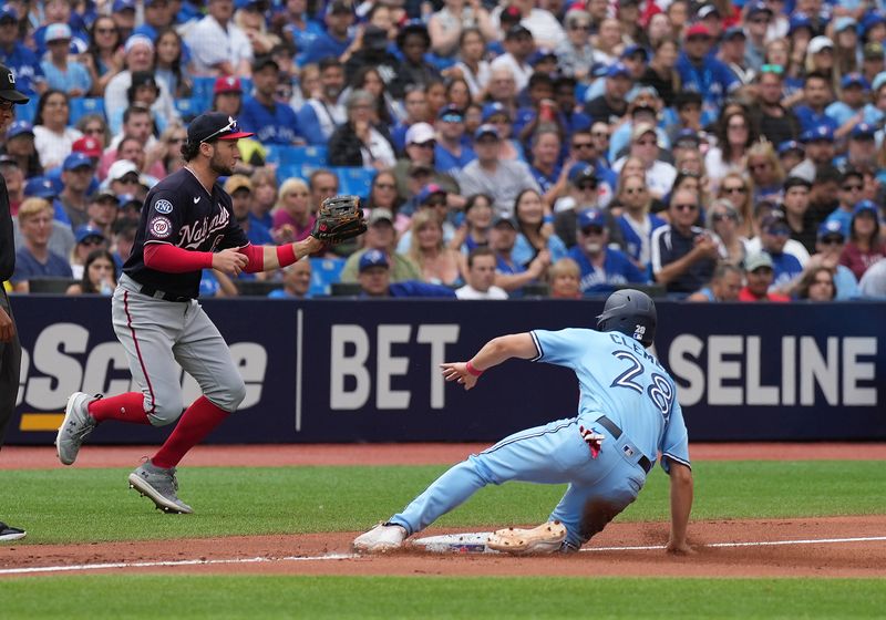 Aug 30, 2023; Toronto, Ontario, CAN; Toronto Blue Jays shortstop Ernie Clement (28) slides into third base safe ahead of the tag from Washington Nationals third baseman Carter Kieboom (8) during the fourth inning at Rogers Centre. Mandatory Credit: Nick Turchiaro-USA TODAY Sports