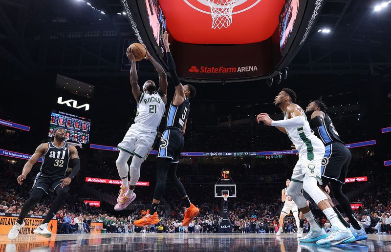 ATLANTA, GEORGIA - MARCH 30:  Patrick Beverley #21 of the Milwaukee Bucks drives against Dejounte Murray #5 of the Atlanta Hawks during the third quarter at State Farm Arena on March 30, 2024 in Atlanta, Georgia.  NOTE TO USER: User expressly acknowledges and agrees that, by downloading and/or using this photograph, user is consenting to the terms and conditions of the Getty Images License Agreement.  (Photo by Kevin C. Cox/Getty Images)