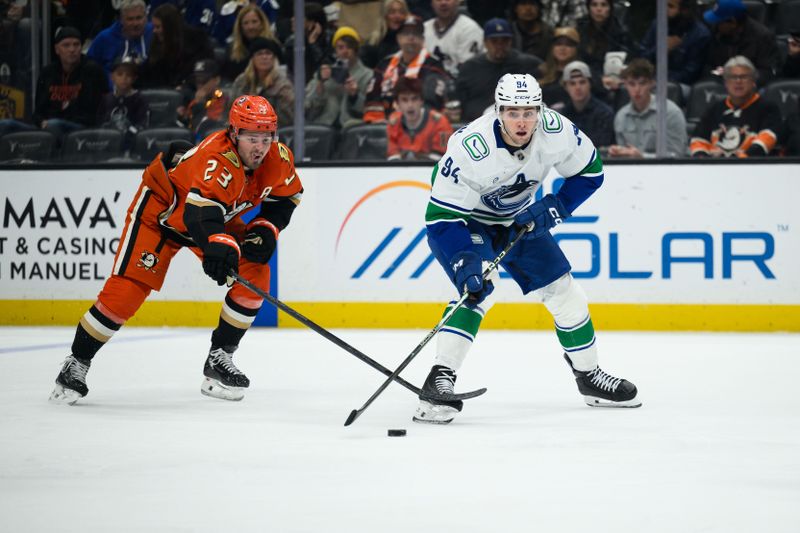 Nov 26, 2025; Anaheim, California, USA; Vancouver Canucks center Linus Karlsson (94) and Anaheim Ducks center Mason McTavish (23) vie for the puck during the first period at Honda Center. Mandatory Credit: William Liang-Imagn Images
