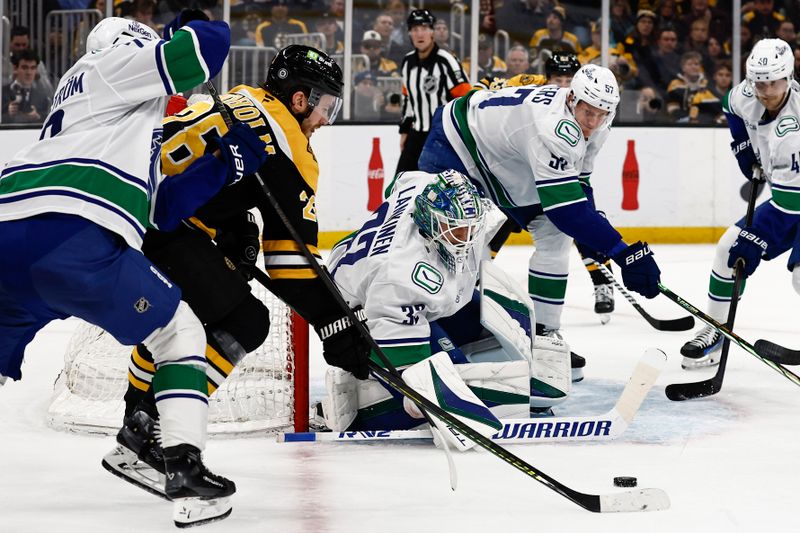 Nov 26, 2024; Boston, Massachusetts, USA; Boston Bruins center Elias Lindholm (28) tries to get to a loose puck next to Vancouver Canucks goaltender Kevin Lankinen (32) during the first period at TD Garden. Mandatory Credit: Winslow Townson-Imagn Images