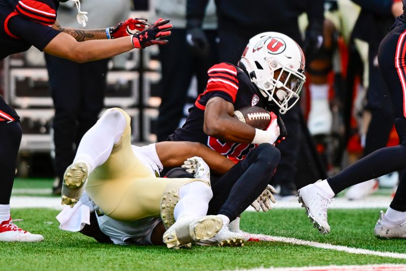 Nov 25, 2023; Salt Lake City, Utah, USA; Utah Utes running back Dijon Stanley (30) gets tackled by Colorado Buffaloes defense at Rice-Eccles Stadium. Mandatory Credit: Christopher Creveling-USA TODAY Sports