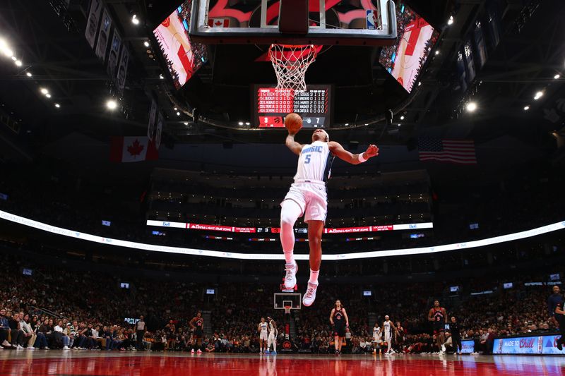 TORONTO, CANADA - MARCH 15:  Paolo Banchero #5 of the Orlando Magic drives to the basket during the game against the Toronto Raptors on March 15, 2024 at the Scotiabank Arena in Toronto, Ontario, Canada.  NOTE TO USER: User expressly acknowledges and agrees that, by downloading and or using this Photograph, user is consenting to the terms and conditions of the Getty Images License Agreement.  Mandatory Copyright Notice: Copyright 2024 NBAE (Photo by Vaughn Ridley/NBAE via Getty Images)