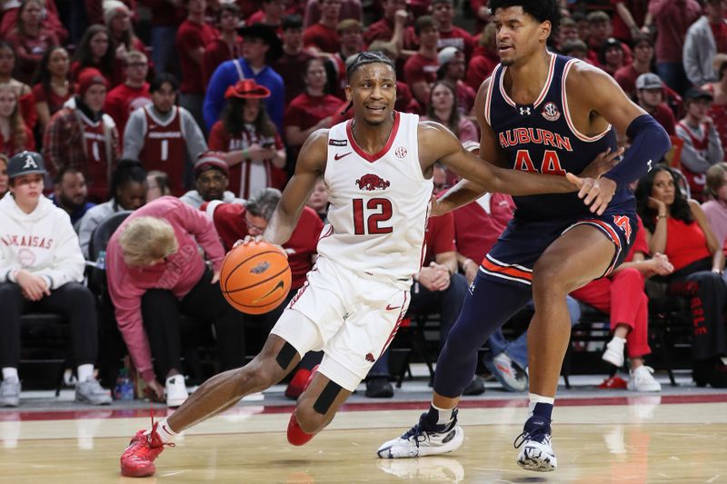 Jan 6, 2024; Fayetteville, Arkansas, USA; Arkansas Razorbacks guard Tramon Mark (12) drives against Auburn Tigers center Dylan Cardwell (44) during the second half at Bud Walton Arena. Auburn won 83-51. Mandatory Credit: Nelson Chenault-USA TODAY Sports