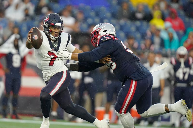 Houston Texans quarterback C.J. Stroud (7) tries to elude New England Patriots defensive tackle Daniel Ekuale, right, during the first half of an NFL preseason football game, Thursday, Aug. 10, 2023, in Foxborough, Mass. (AP Photo/Steven Senne)