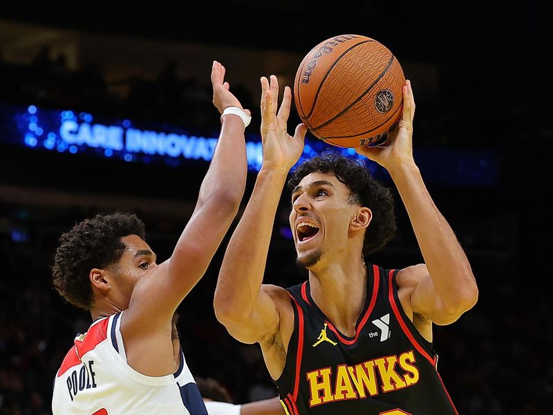 ATLANTA, GEORGIA - NOVEMBER 15:  Zaccharie Risacher #10 of the Atlanta Hawks draws a foul as he drives against Jordan Poole #13 of the Washington Wizards during the fourth quarter of the Emirates NBA Cup game at State Farm Arena on November 15, 2024 in Atlanta, Georgia.  NOTE TO USER: User expressly acknowledges and agrees that, by downloading and/or using this photograph, user is consenting to the terms and conditions of the Getty Images License Agreement.  (Photo by Kevin C. Cox/Getty Images)