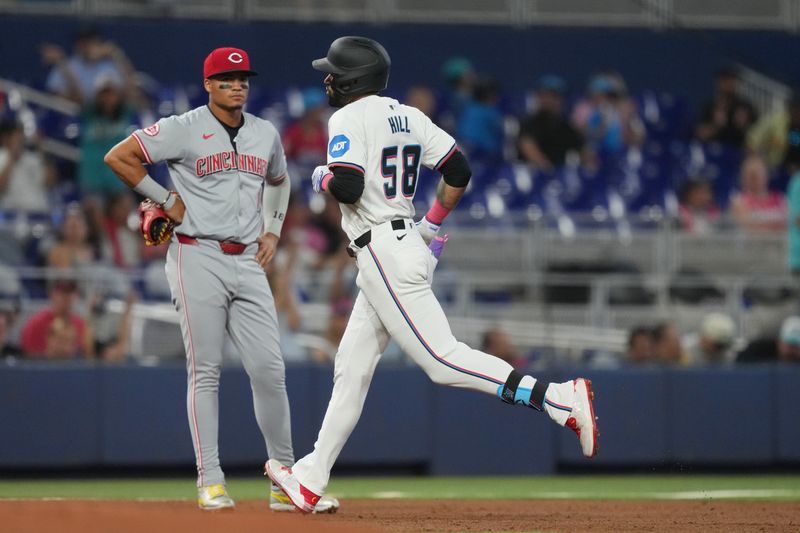 Aug 7, 2024; Miami, Florida, USA;  Miami Marlins left fielder Derek Hill (58) rounds the bases after hitting a grand slam as Cincinnati Reds third baseman Noelvi Marte (16) looks on in the first inning at loanDepot Park. Mandatory Credit: Jim Rassol-USA TODAY Sports