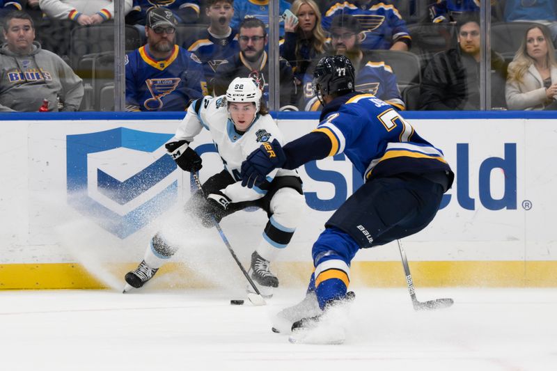 Nov 7, 2024; St. Louis, Missouri, USA; Utah Hockey Club center Logan Cooley (92) controls the puck from St. Louis Blues defenseman Pierre-Olivier Joseph (77) during the first period at Enterprise Center. Mandatory Credit: Jeff Le-Imagn Images