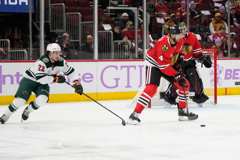 Jan 26, 2025; Chicago, Illinois, USA; Minnesota Wild center Marat Khusnutdinov (22) defends Chicago Blackhawks defenseman Seth Jones (4) during the second period at United Center. Mandatory Credit: David Banks-Imagn Images