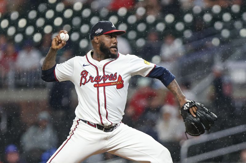 Apr 22, 2025; Cumberland, Georgia, USA; Atlanta Braves pitcher Enyel De Los Santos (61) pitches the ball against the St. Louis Cardinals during the eighth inning at Truist Park. Mandatory Credit: Jordan Godfree-Imagn Images