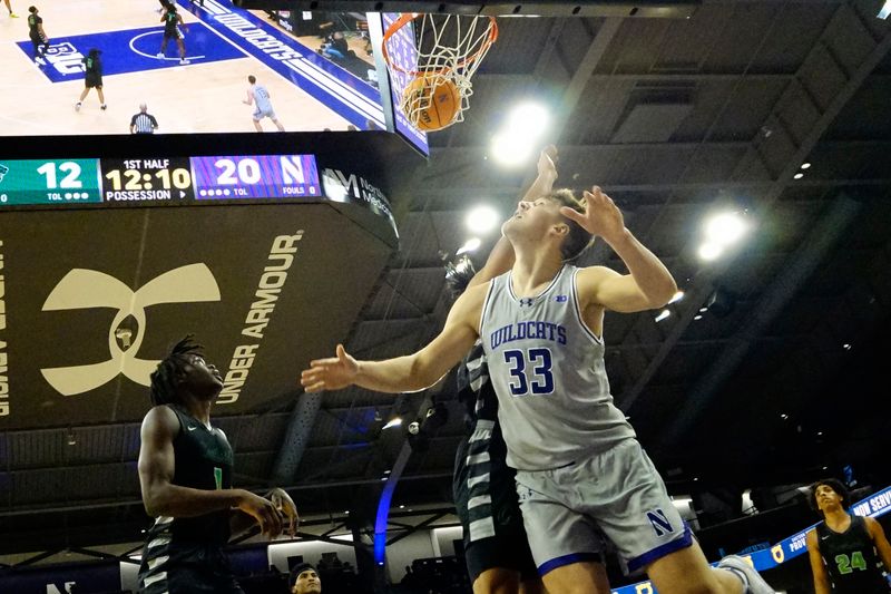 Dec 13, 2023; Evanston, Illinois, USA; Northwestern Wildcats forward Luke Hunger (33) scores on Chicago State Cougars guard Wesley Cardet Jr. (1) during the first half at Welsh-Ryan Arena. Mandatory Credit: David Banks-USA TODAY Sports