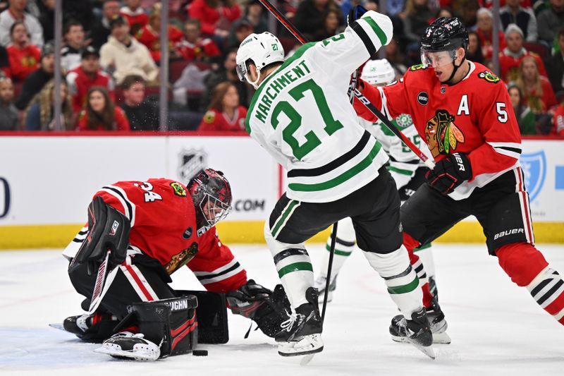 Jan 13, 2024; Chicago, Illinois, USA;  Dallas Stars forward Mason Marchement (27) and Chicago Blackhawks defenseman Connor Murphy (5) battle for control of the puck in front of goaltender Petr Mrazek (34) in the second period at United Center. Mandatory Credit: Jamie Sabau-USA TODAY Sports