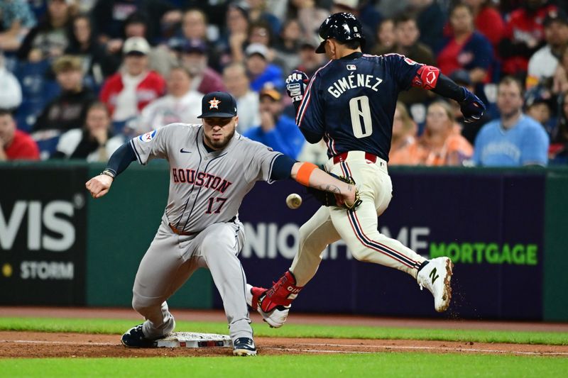 Sep 27, 2024; Cleveland, Ohio, USA; Cleveland Guardians second baseman Andres Gimenez (0) is safe at first as Houston Astros first baseman Victor Caratini (17) misses the throw during the second inning at Progressive Field. Mandatory Credit: Ken Blaze-Imagn Images