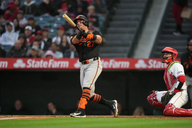 Apr 22, 2024; Anaheim, California, USA; Baltimore Orioles catcher James McCann (27) follows through on a solo home run in the second inning against the Los Angeles Angels at Angel Stadium. Mandatory Credit: Kirby Lee-USA TODAY Sports