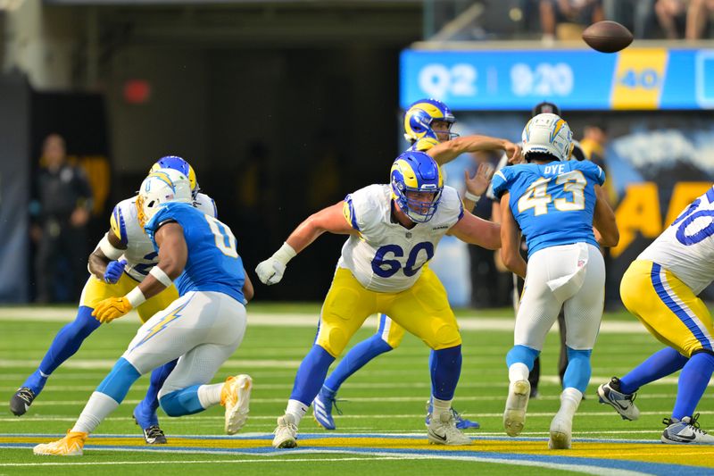 Los Angeles Rams guard Logan Bruss (60) protects quarterback Stetson Bennett during the first half of a preseason NFL football game against the Los Angeles Chargers, Saturday, Aug. 17, 2024, in Inglewood, Calif. (AP Photo/Jayne Kamin-Oncea)