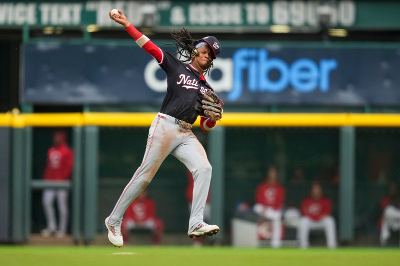 May 4, 2025; Cincinnati, Ohio, USA;  Washington Nationals shortstop CJ Abrams (5) fields the ball and attempts to throw out Cincinnati Reds outfielder Spencer Steer (7) in the fourth inning at Great American Ball Park. Mandatory Credit: Aaron Doster-Imagn Images