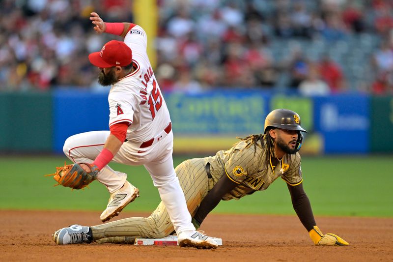 Jun 4, 2024; Anaheim, California, USA;  San Diego Padres right fielder Fernando Tatis Jr. (23) is safe as he dives back to second and avoids a tag by Los Angeles Angels second baseman Luis Guillorme (15) in the third inning at Angel Stadium. Mandatory Credit: Jayne Kamin-Oncea-USA TODAY Sports