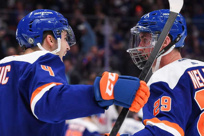 Apr 6, 2023; Elmont, New York, USA; New York Islanders defenseman Samuel Bolduc (4) celebrates the goal by center Brock Nelson (29) against the Tampa Bay Lightning during the second period at UBS Arena. Mandatory Credit: Dennis Schneidler-USA TODAY Sports