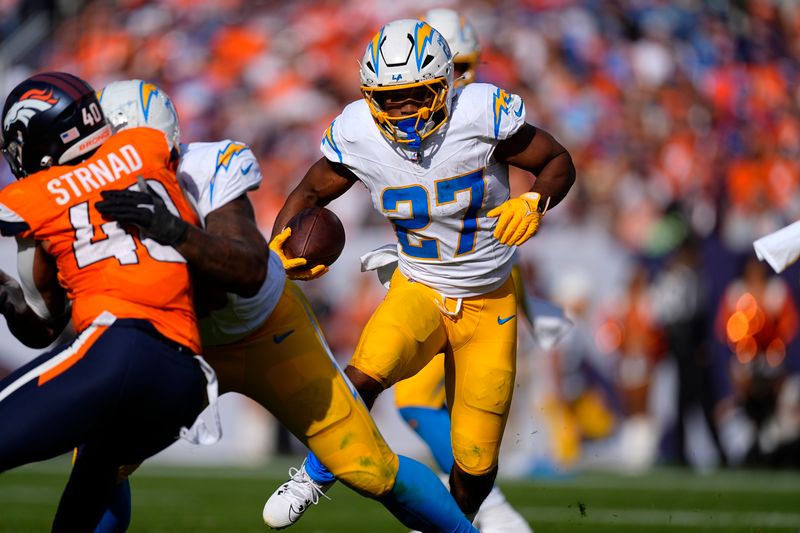 Los Angeles Chargers running back J.K. Dobbins (27) runs with the football during the first half of an NFL football game against the Denver Broncos, Sunday, Oct. 13, 2024, in Denver. (AP Photo/David Zalubowski)