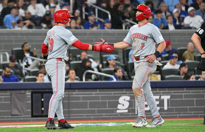 Aug 19, 2024; Toronto, Ontario, CAN; Cincinnati Reds center fielder TJ Friedl (29) greets left fielder Spencer Steer (7) after both scored against the Toronto Blue Jays in the sixth inning at Rogers Centre. Mandatory Credit: Dan Hamilton-USA TODAY Sports