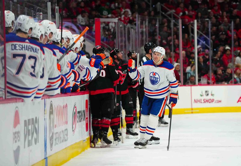 Nov 22, 2023; Raleigh, North Carolina, USA; Edmonton Oilers left wing Zach Hyman (18) is congratulated after his goal against the Carolina Hurricanes during the third period at PNC Arena. Mandatory Credit: James Guillory-USA TODAY Sports