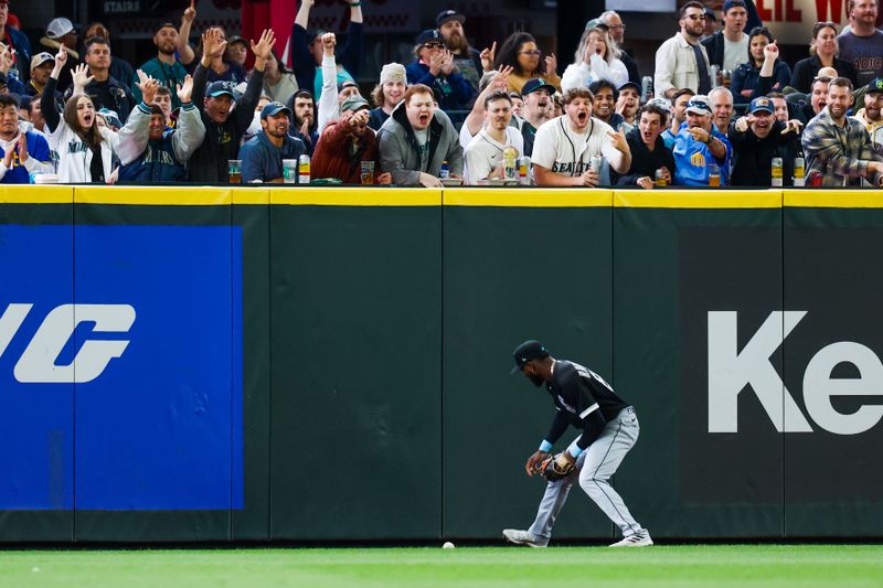 Jun 18, 2023; Seattle, Washington, USA; Chicago White Sox center fielder Luis Robert Jr. (88) picks up a triple off the warning track against the Seattle Mariners during the eighth inning at T-Mobile Park. Mandatory Credit: Joe Nicholson-USA TODAY Sports