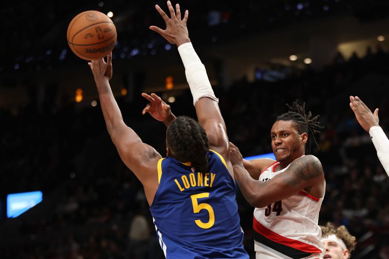 PORTLAND, OREGON - APRIL 11: Jabari Walker #34 of the Portland Trail Blazers passes the ball against Kevon Looney #5 of the Golden State Warriors during the fourth quarter at Moda Center on April 11, 2024 in Portland, Oregon. NOTE TO USER: User expressly acknowledges and agrees that, by downloading and or using this photograph, User is consenting to the terms and conditions of the Getty Images License Agreement.? (Photo by Amanda Loman/Getty Images)