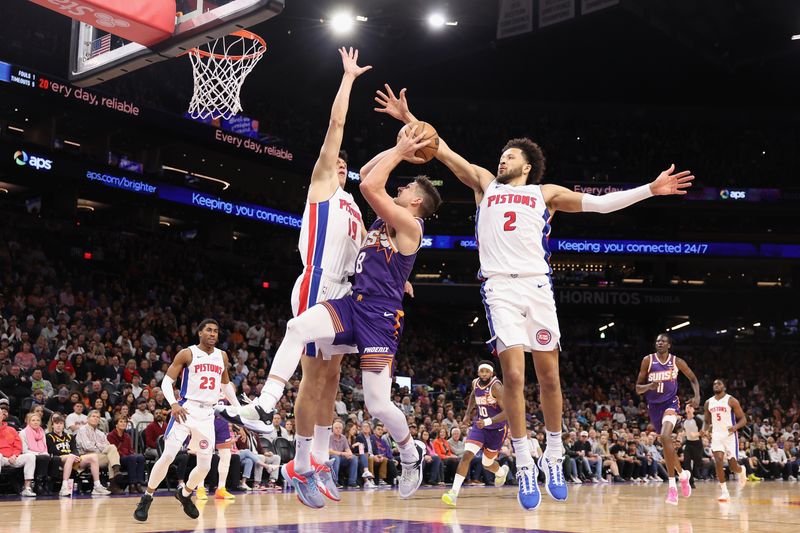 PHOENIX, ARIZONA - FEBRUARY 14:  Grayson Allen #8 of the Phoenix Suns attempts a shot against Simone Fontecchio #19 and Cade Cunningham #2 of the Detroit Pistons during the first half of the NBA game at Footprint Center on February 14, 2024 in Phoenix, Arizona. NOTE TO USER: User expressly acknowledges and agrees that, by downloading and or using this photograph, User is consenting to the terms and conditions of the Getty Images License Agreement.  (Photo by Christian Petersen/Getty Images)