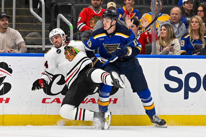 Apr 10, 2024; St. Louis, Missouri, USA;  St. Louis Blues right wing Alexey Toropchenko (13) checks Chicago Blackhawks defenseman Jaycob Megna (24) during the first period at Enterprise Center. Mandatory Credit: Jeff Curry-USA TODAY Sports