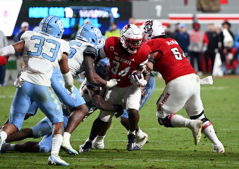 Nov 25, 2023; Raleigh, North Carolina, USA; North Carolina State Wolfpack running back Delbert Mimms III (34) runs the ball against the North Carolina Tar Heels during the second half at Carter-Finley Stadium. Mandatory Credit: Rob Kinnan-USA TODAY Sports