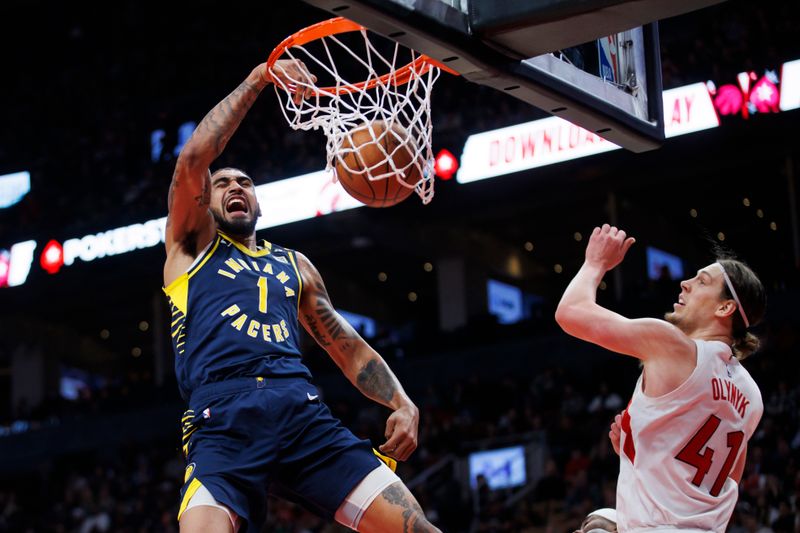 TORONTO, CANADA - APRIL 9: Obi Toppin #1 of the Indiana Pacers dunks against Kelly Olynyk #41 of the Toronto Raptors during the second half of their NBA game at Scotiabank Arena on April 9, 2024 in Toronto, Canada. NOTE TO USER: User expressly acknowledges and agrees that, by downloading and or using this photograph, User is consenting to the terms and conditions of the Getty Images License Agreement. (Photo by Cole Burston/Getty Images)