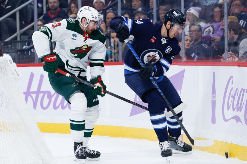 Nov 23, 2025; Winnipeg, Manitoba, CAN;  Winnipeg Jets defenseman Logan Stanley (64) tries to skate away from Minnesota Wild forward Yakov Trenin (13) during the first period at Canada Life Centre. Mandatory Credit: Terrence Lee-Imagn Images