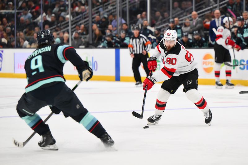 Jan 6, 2025; Seattle, Washington, USA; New Jersey Devils left wing Tomas Tatar (90) passes the puck during the second period against the Seattle Kraken at Climate Pledge Arena. Mandatory Credit: Steven Bisig-Imagn Images