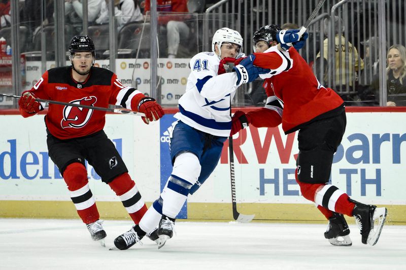 Feb 25, 2024; Newark, New Jersey, USA; Tampa Bay Lightning right wing Mitchell Chaffee (41) tries to get past New Jersey Devils defenseman John Marino (6) during the third period at Prudential Center. Mandatory Credit: John Jones-USA TODAY Sports