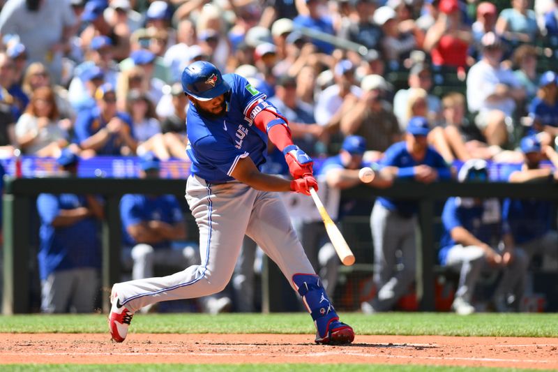 Jul 6, 2024; Seattle, Washington, USA; Toronto Blue Jays first baseman Vladimir Guerrero Jr. (27) hits an RBI sacrifice fly against the Seattle Mariners during the eighth inning at T-Mobile Park. Mandatory Credit: Steven Bisig-USA TODAY Sports