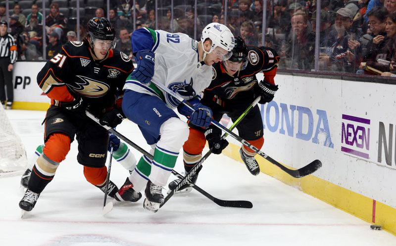 Mar 3, 2024; Anaheim, California, USA; Vancouver Canucks right wing Vasily Podkolzin (92) chases the puck against Anaheim Ducks defenseman Olen Zellweger and center Ryan Strome (16) during the first period at Honda Center. Mandatory Credit: Jason Parkhurst-USA TODAY Sports