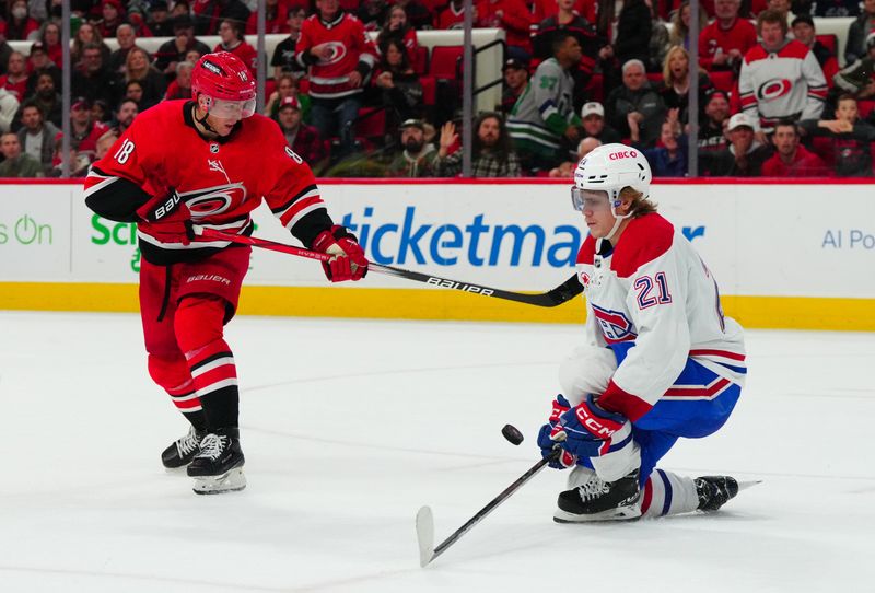 Dec 28, 2023; Raleigh, North Carolina, USA; Montreal Canadiens defenseman Kaiden Guhle (21) blocks Carolina Hurricanes center Jack Drury (18) shot during the third period at PNC Arena. Mandatory Credit: James Guillory-USA TODAY Sports