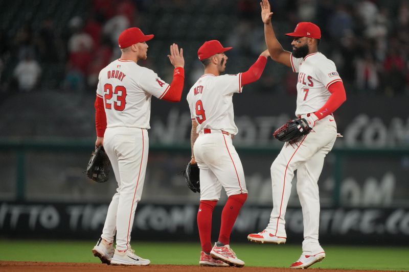 Jun 17, 2024; Anaheim, California, USA; Los Angeles Angels right fielder Jo Adell (7), shortstop Zach Neto (9) and second baseman Brandon Drury (23) celebrate at the end of the game against the Milwaukee Brewers at Angel Stadium. Mandatory Credit: Kirby Lee-USA TODAY Sports