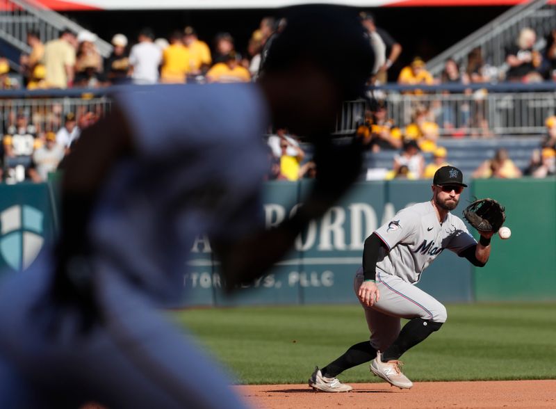 Oct 1, 2023; Pittsburgh, Pennsylvania, USA;  Miami Marlins third baseman Jon Berti (5) fields a ground ball for an out against Pittsburgh Pirates catcher Jason Delay (left) during the fifth inning at PNC Park. Pittsburgh won 3-0. Mandatory Credit: Charles LeClaire-USA TODAY Sports