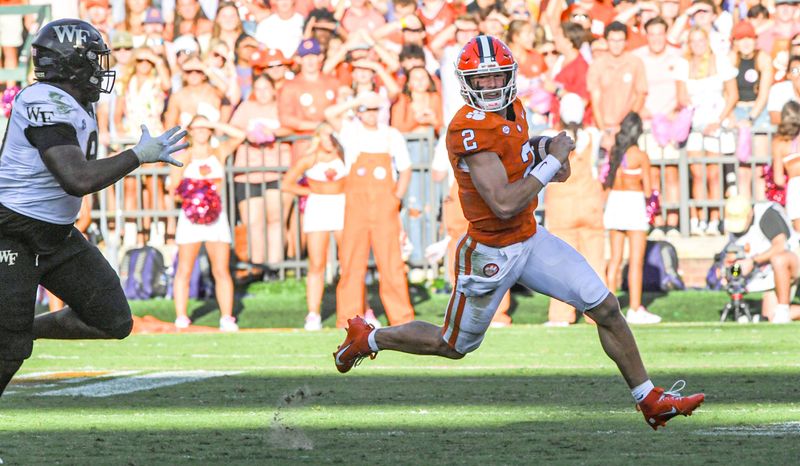 Oct 7, 2023; Clemson, South Carolina, USA; Clemson Tigers quarterback Cade Klubnik (2) runs by Wake Forest Demon Deacons defensive lineman Jasheen Davis (30) during the third quarter at Memorial Stadium. Mandatory Credit: Ken Ruinard-USA TODAY Sports