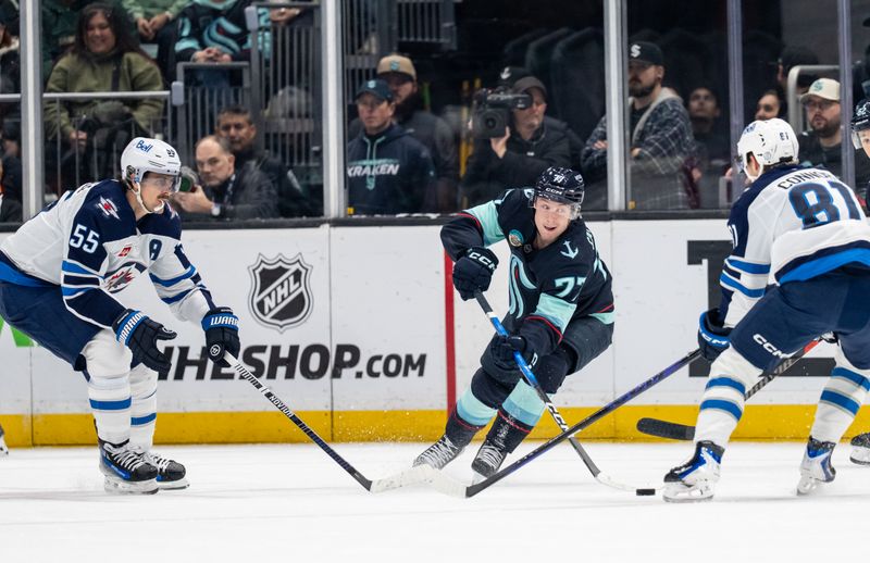 Nov 13, 2025; Seattle, Washington, USA; Seattle Kraken forward Berkly Catton (77) skates aginst Winnipeg Jets forward Mark Scheifele (55) and forward Kyle Connor (81) during the first period at Climate Pledge Arena. Mandatory Credit: Stephen Brashear-Imagn Images