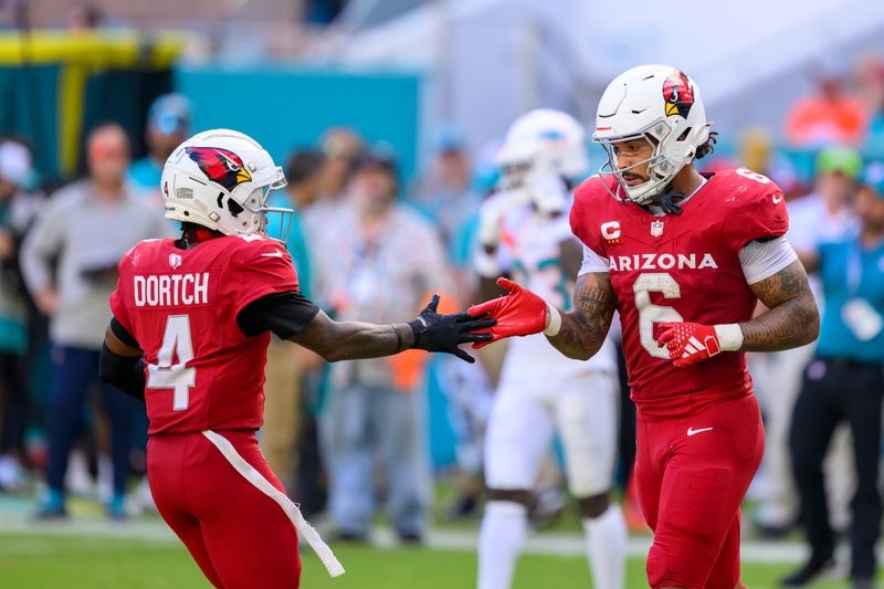 Arizona Cardinals running back James Conner (6) celebrates scoring a touchdown with Arizona Cardinals wide receiver Greg Dortch (4) during an NFL football game against the Miami Dolphins, Sunday, Oct. 27, 2024, in Miami Gardens, Fla. (AP Photo/Doug Murray)