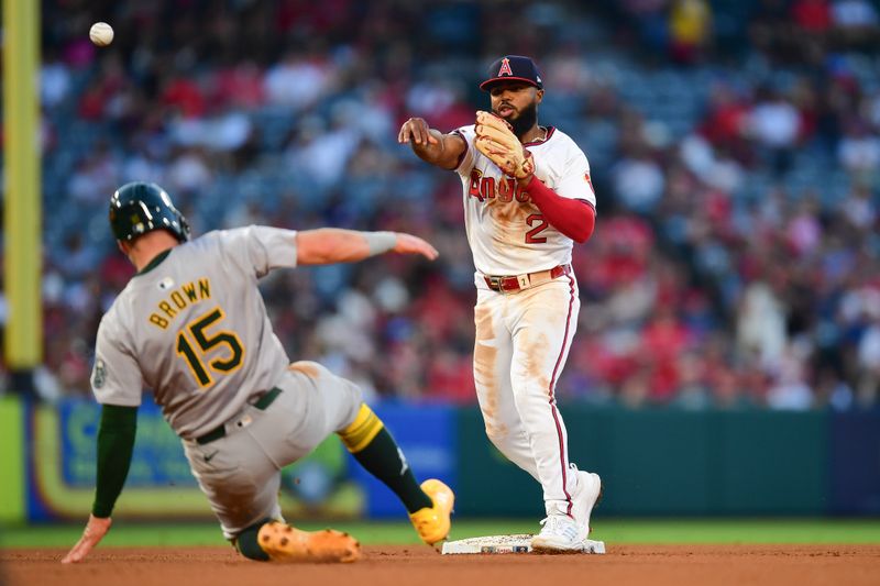 Jul 26, 2024; Anaheim, California, USA; Oakland Athletics first baseman Seth Brown (15) is out at second as Los Angeles Angels second baseman Luis Rengifo (2) throws to first for the out against shortstop Max Schuemann (12) during the fifth inning at Angel Stadium. Mandatory Credit: Gary A. Vasquez-USA TODAY Sports