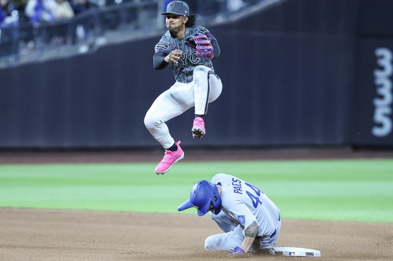 May 24, 2025; New York City, New York, USA;  New York Mets shortstop Francisco Lindor (12) leaps over Los Angeles Dodgers left fielder Andy Pages (44) attempting to complete a double play in the seventh inning at Citi Field. Mandatory Credit: Wendell Cruz-Imagn Images
