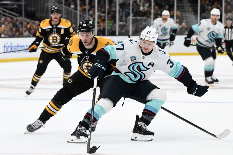 Nov 3, 2024; Boston, Massachusetts, USA; Seattle Kraken center Yanni Gourde (37) skates with the puck against Boston Bruins center Charlie Coyle (13) during the second period at the TD Garden. Mandatory Credit: Brian Fluharty-Imagn Images