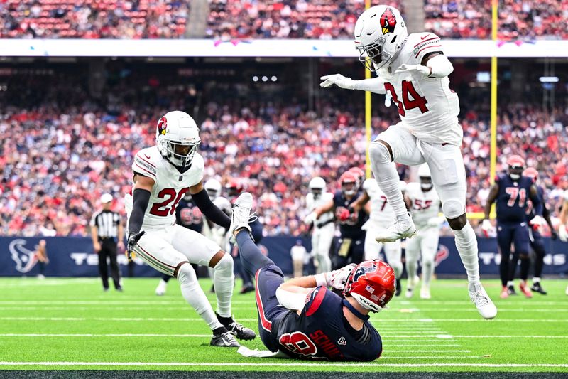 Houston Texans tight end Dalton Schultz (86) slides into the end zone for a touchdown as Arizona Cardinals safety Jalen Thompson (34) leaps over him and Arizona Cardinals cornerback Marco Wilson (20) defends during an NFL football game, Sunday, Nov 19, 2023, in Houston. (AP Photo/Maria Lysaker)