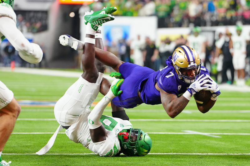 Dec 1, 2023; Las Vegas, NV, USA; Washington Huskies running back Dillon Johnson (7) is tackled by Oregon Ducks defensive back Dontae Manning (8) during the fourth quarter at Allegiant Stadium. Mandatory Credit: Stephen R. Sylvanie-USA TODAY Sports