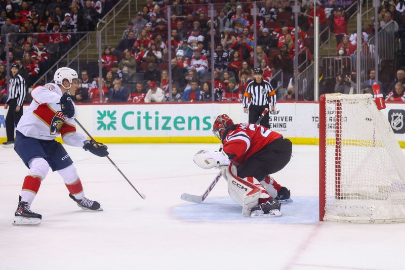 Jan 14, 2025; Newark, New Jersey, USA; Florida Panthers center Anton Lundell (15) scores the game winning goal on New Jersey Devils goaltender Jacob Markstrom (25) during the overtime shootout at Prudential Center. Mandatory Credit: Ed Mulholland-Imagn Images