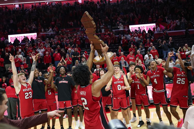 Dec 14, 2024; Piscataway, New Jersey, USA; Rutgers Scarlet Knights guard Dylan Harper (2) celebrates with teammates while hosting the Garden State Hardwood Classic trophy after defeating the Seton Hall Pirates at Jersey Mike's Arena. Mandatory Credit: Vincent Carchietta-Imagn Images