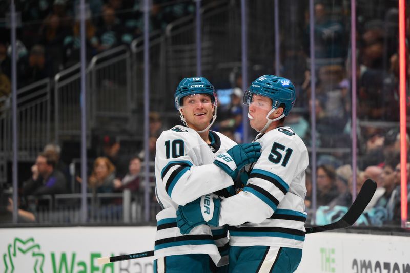 Nov 5, 2025; Seattle, Washington, USA; San Jose Sharks center Ty Dellandrea (10) and right wing Collin Graf (51) hug after Dellandrea scored a goal against the Seattle Kraken during the third period at Climate Pledge Arena. Mandatory Credit: Steven Bisig-Imagn Images